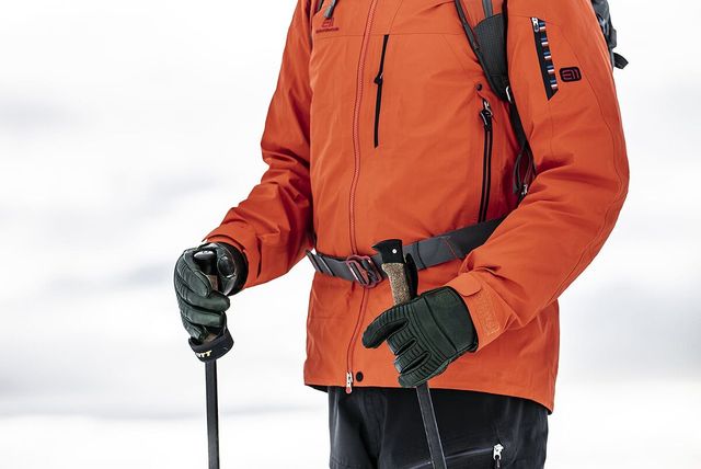 man wearing snow gear carrying ski poles