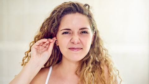 vrouw steekt wattenstaafje in haar oren