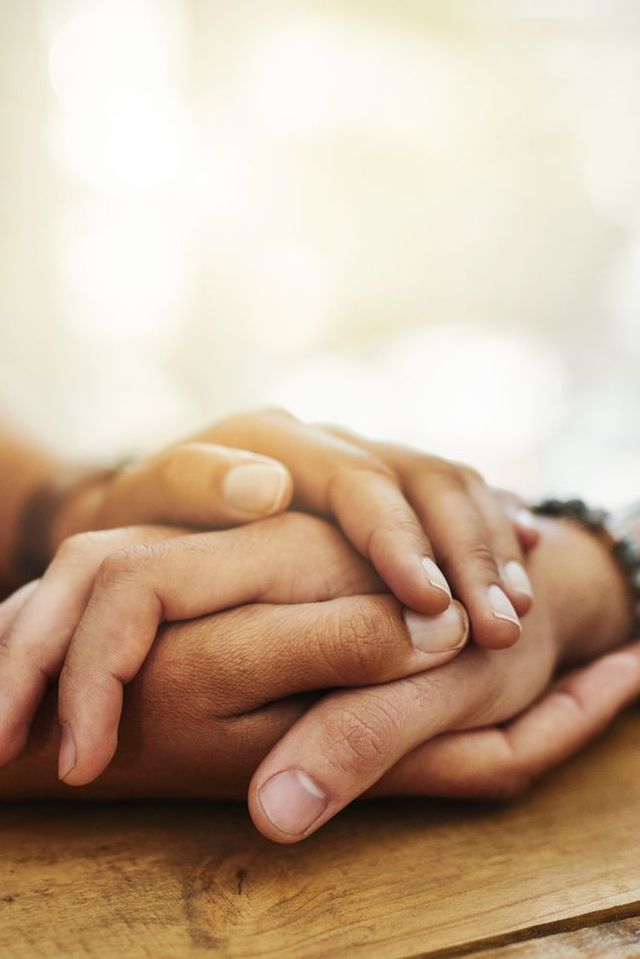 two people's hands holding each others' in comfort