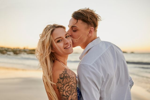 beach, love and man kissing his wife on the cheek while on holiday, weekend trip or adventure portrait, romance and young guy with affection for woman by ocean or sea while on vacation in australia
