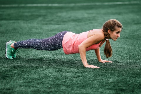 Taytlı ve yelekli güzel kaslı bir kız stadyumda ısınma yapar. spor salonu, fitness, sağlıklı yaşam tarzı