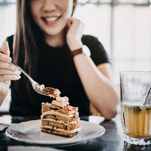 beautiful smiling young asian woman having cake and iced tea relaxing and enjoying the moment in the afternoon in the cafe