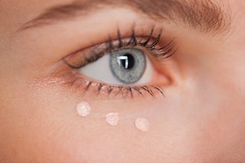 Beautiful woman applying concealer