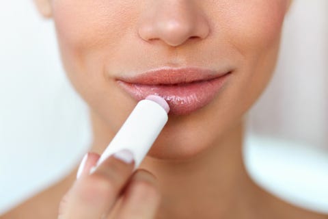 Beautiful Woman Applying Lip Protector On Lips Skin. Beauty