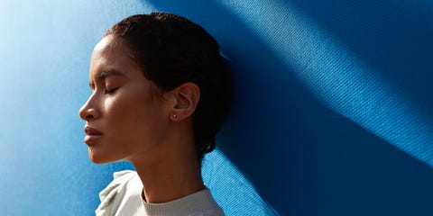 Beautiful woman standing against blue wall beautiful woman standing against blue wall