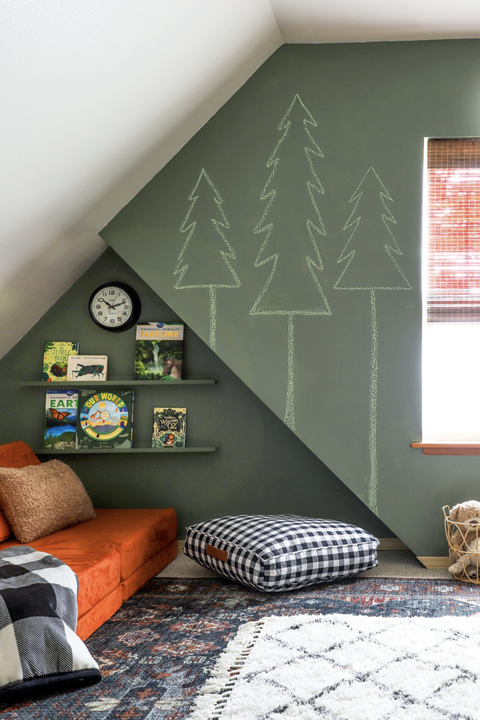 green bedroom with a chalkboard wall and orange sofa