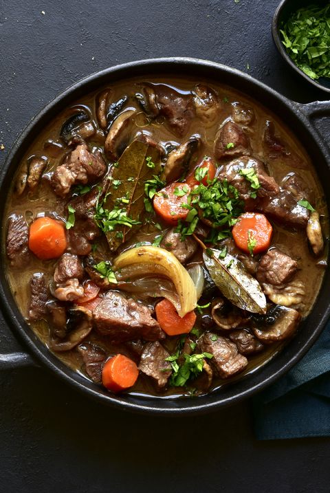 beef bourguignon meat stew with vegetables and mushrooms with red wine in a skillet