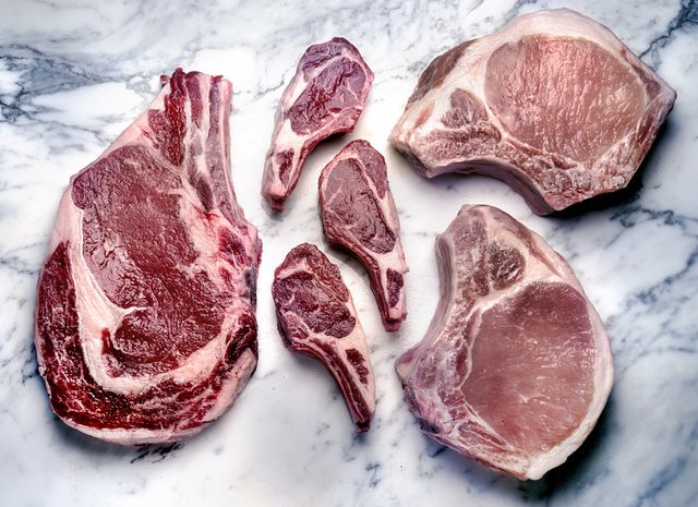 een marmeren plaat met daarop rundvlees, varkensvlees en lamsvlees