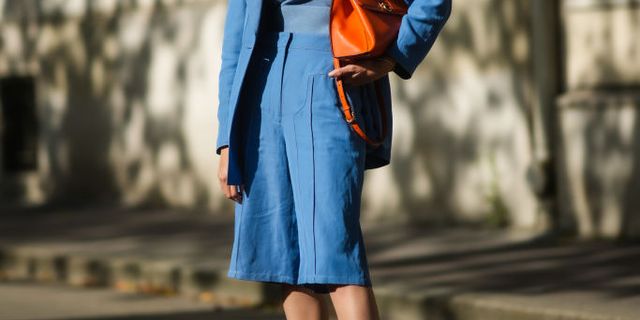 paris, france   july 08 natalia verza wears sunglasses, earrings, a blue wool pullover, a blue flowing blazer jacket, blue knees flowing short, an orange shiny leather handbag from salvatore ferragamo, gold leather with white  blue  yellow  red  green suede strappy sandals wedge heel, a gold bracelet, during paris fashion week   haute couture fallwinter 20212022, on july 08, 2021 in paris, france photo by edward berthelotgetty images