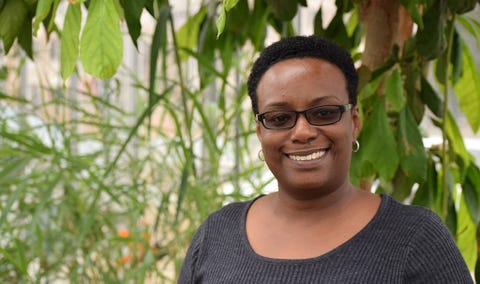 beronda in front of tall intersecting plants in a greenhouse