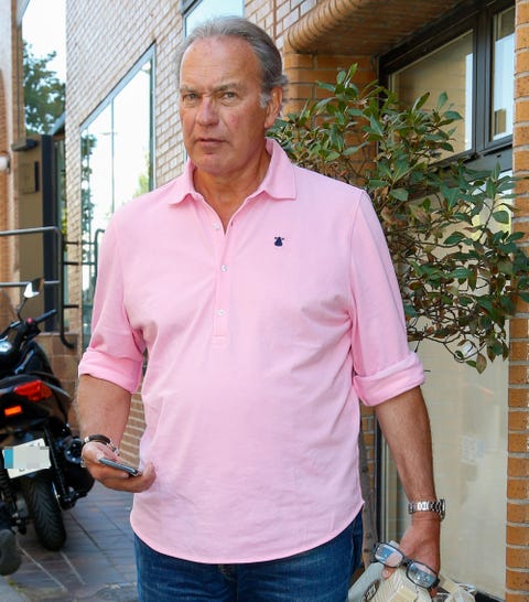 Bertín Osborne el presentador, con una camisa rosa y teléfono en mano, en una calle de madrid