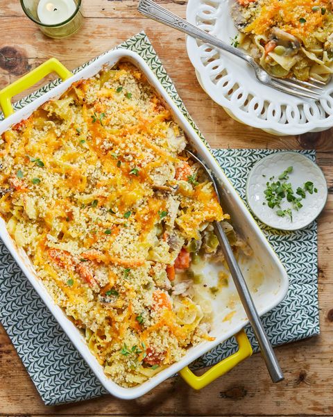 ground chicken noodle casserole in a rectangle baking dish with a large serving spoon and a portion remvoed