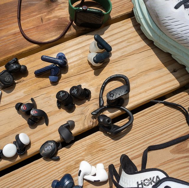 variety of headphones laying next to shoes and an apple watch