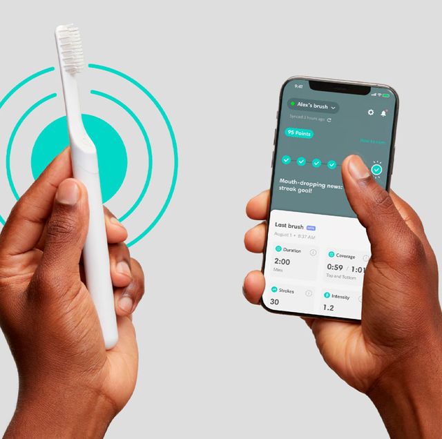 two hands holding a bluetooth quip toothbrush and phone