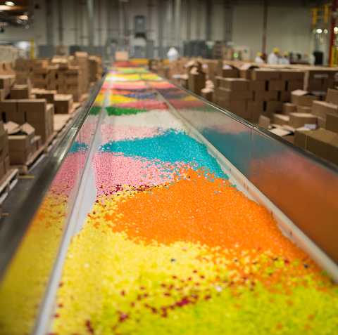 brightly colored candies go down the mixing line in the jelly belly factory, a good housekeeping pick for best factory tours