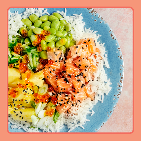salmon edamame rice and veggies over rice shot from above in a blue bowl