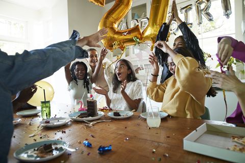 friends cheering for woman during birthday party at home