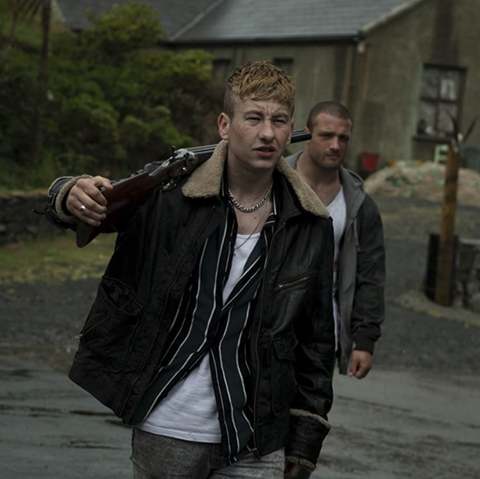 barry keoghan as dymphna holds a rifle over his shoulder in a scene from shadow of violence, a good housekeeping pick for best irish movies on netflix