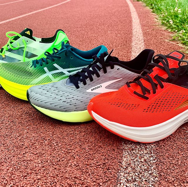 four running shoes on a track