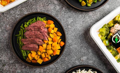 steak with sweet potatoes and asparagus and chicken with broccoli on a marble countertop from fresh n lean, a good housekeeping pick for best meal delivery service