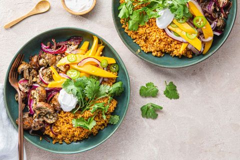 a vegan meal of rice, mushrooms and mango in a teal bowl on a slate countertop from purple carrot, a good housekeeping pick for best healthy meal delivery service