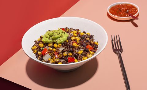 a grain bowl with guacamole on a red and pink background from sunbasket, a good housekeeping pick for best meal delivery service