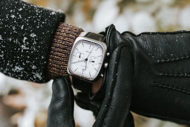a person wearing a watch with gloves in the snow