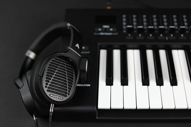black audeze headphones laying on piano