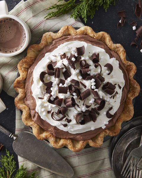 hot chocolate ice box pie in a metal pie plate with two mugs of hot cocoa and a pie server next to it