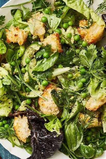 a close up of green panzanella salad with croutons