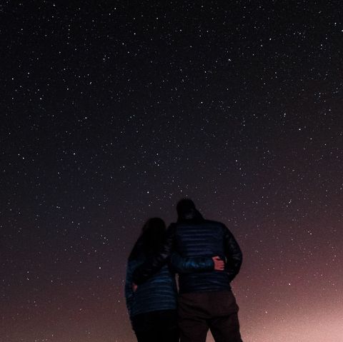 low angle view of couple standing against star field
