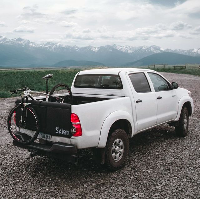 white truck parked on gravel overlooking mountains with a sklon bike mat and bike in back of truck bed