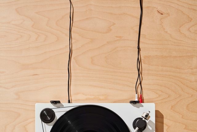 a hand putting on a record on a turntable