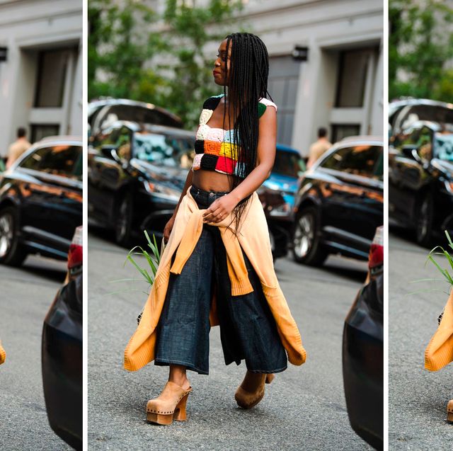 a woman walks down the street during new york fashion week wearing wide leg jeans to illustrate a roundup of the best wide leg jeans for women 2022