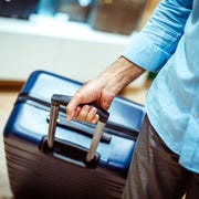 Big navy blue travel suitcase being held by an unrecognizable person in a bags and accessories store big navy blue travel suitcase being held by an unrecognizable person in a bags and accessories store
