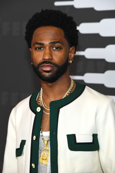 big sean wears a black and white jacket, a white tank top, and gold chain necklaces on the red carpet