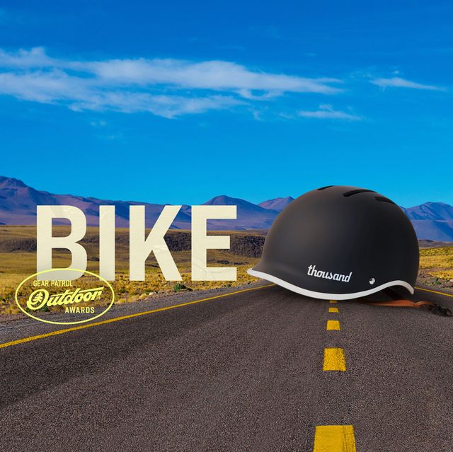 a helmet on a road landscape with a bike headline and outdoor badge icon