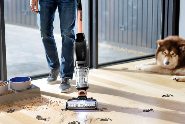 man vacuuming dirty paw prints with bissell vacuum