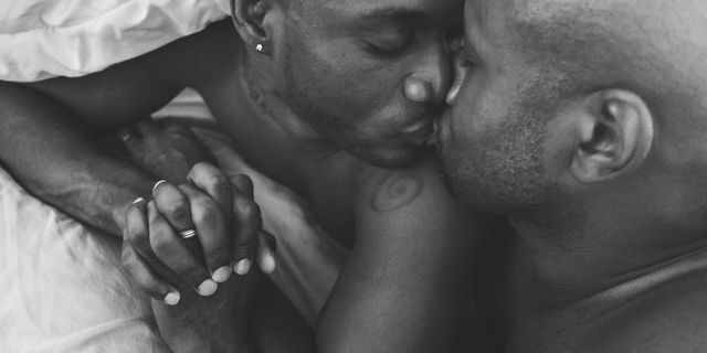 two men in bed kissing