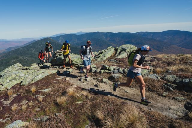 a group of people mountain running on a ridgeline