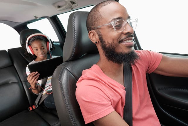 black father and daughter driving in car