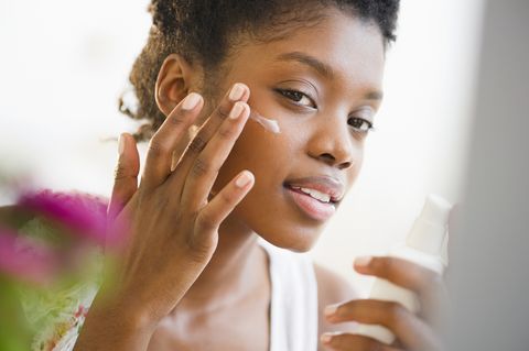 spf meaning black woman putting on face lotion