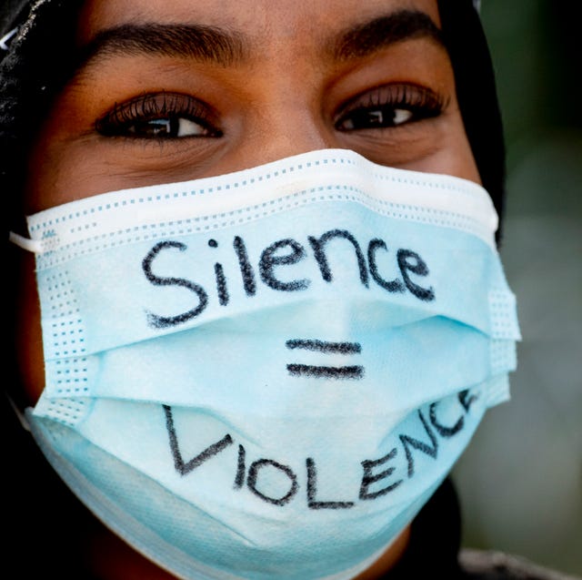 Jonge vrouw draagt een gezichtsmasker tijdens een protest jonge vrouw tijdens een protest in den haag met gezichtsmasker