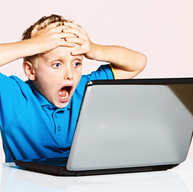 Blond 9-year-old boy is shocked by something on his laptop