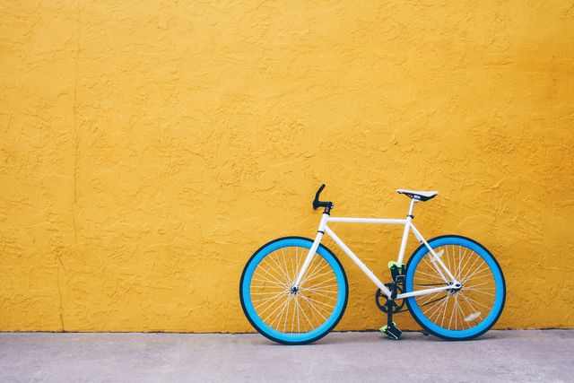 blue bicycle against yellow wall