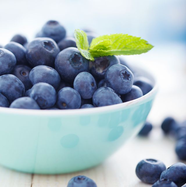 a blue bowl overfilled with blueberries