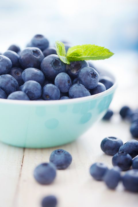A blue bowl overfilled with blueberries