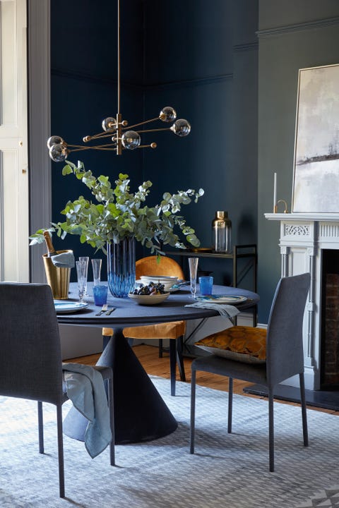 Blue dining room with round table and pendant light dining room round dining table, blue vase in the middle of the tablerich palettefor a luxurious look, use the same shade on walls and furniture an accent chair in velvet and polishedbrass accessories add layers of interest in this elegant schemewalls in velvet blue elite emulsion, £4625l, zoffany clay table, £5,845 by desalto bronte chairs in indigo velvet, £399 for two all heal’s manipur ochre cushion, £75, designers guild moritz chair in amber, £299, john lewis partners lena brass champagne cooler, £72 elsa fluted champagne glasses, £32 for two all rowen wren bubble glasses in deep blue, £11 each, by memento, the conran shop ripple column vase, £69, heal’s kelp bowls, £38 each, by brickett davda slate linen napkins, £1250 each all the conran shop constantine bay dinner plates, £14 each, by rick stein at unique unity jenny salad plates, £28 each, 1882 ltd matt gold 16 piece cutlery set, £75 abstract skyline framed canvas, £195 both cox cox pendant light, £180, debenhams katiya platinum rug, £1,195, designers guild