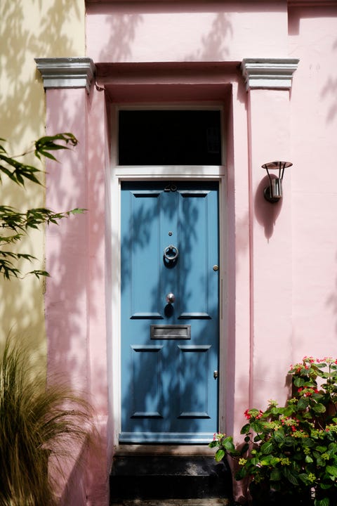 blue front door, pastel pink exterior of traditional british residential building