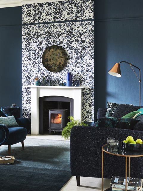 living room of dark green and bluescentrepiece white highlights thechimney breast and fireplace, makingthemthe stars of the show